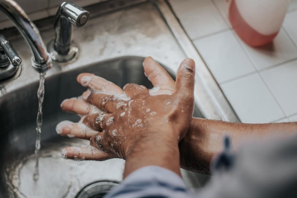 Image of someone washing their hands with plenty of soap and water under a running tap